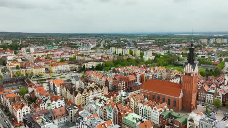 Eine-Ausgedehnte-Luftaufnahme-Von-Elbląg-Zeigt-Den-Kontrast-Zwischen-Dem-Lebendigen,-Historischen-Zentrum-Mit-Seinen-Farbenfrohen-Dächern-Und-Der-Modernen-Vorstadtlandschaft