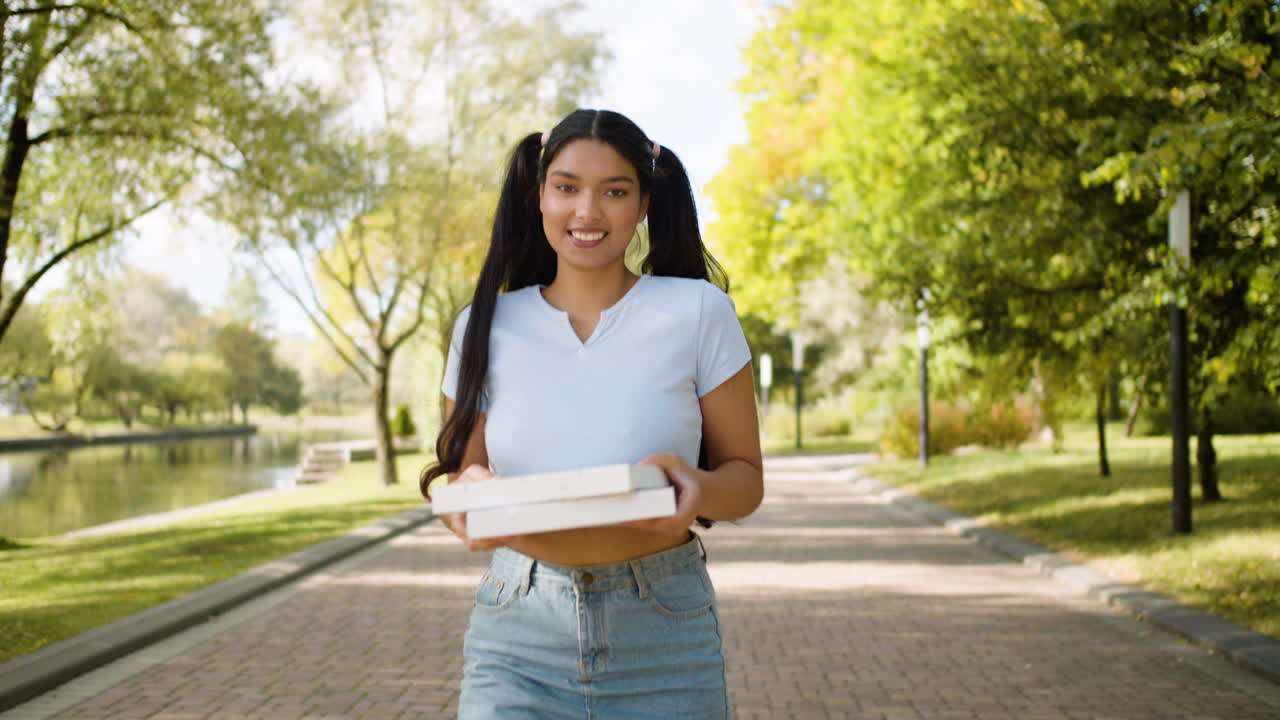 una mujer sonriente caminando por el parque.