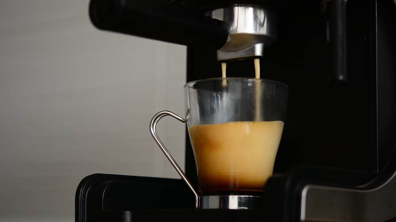 Espresso Coffee Brewing into a Glass Cup