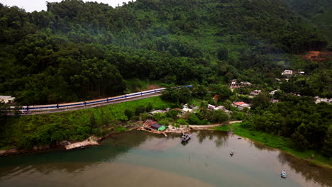 train traveling in scenic landscape from da nang to hue in vietnam - aerial shot