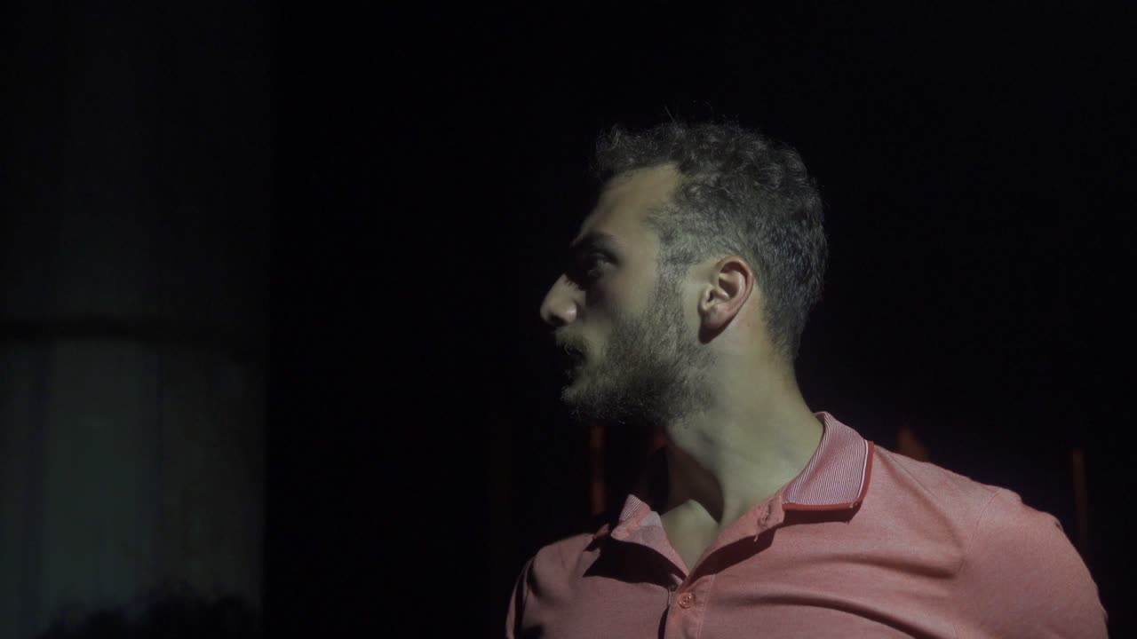 The man looking around in the dark in his dream.