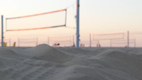 players playing volleyball on beach court, volley ball game with ball and net.