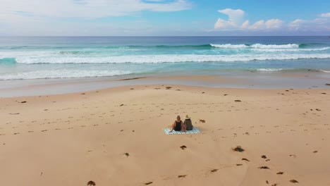 young tourists relaxing at the popular moonee beach near coffs harbour in new south wales, australia. aerial flyover