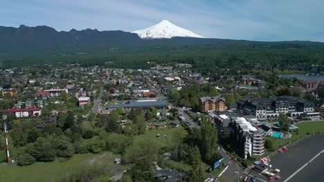 descending drone shot over pucon with stunning view of the town, lake and villarrica volcano in the background on a clear day