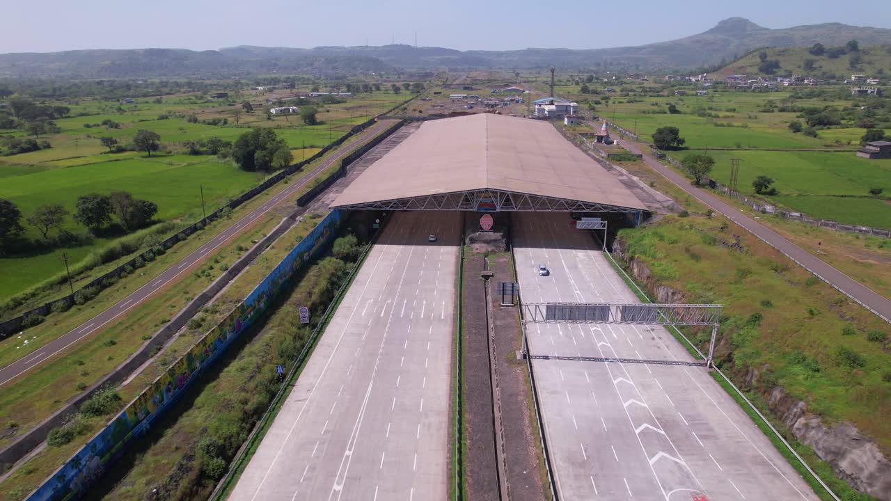 Igatpuri Kasara tunnel on Samruddhi Mahamarg through rural village with agricultural fields, western ghats landscape, Maharashtra, drone shot