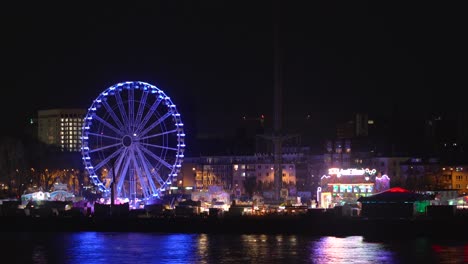 a vibrant carnival comes to life under the night sky, its colorful lights twinkling in the distance