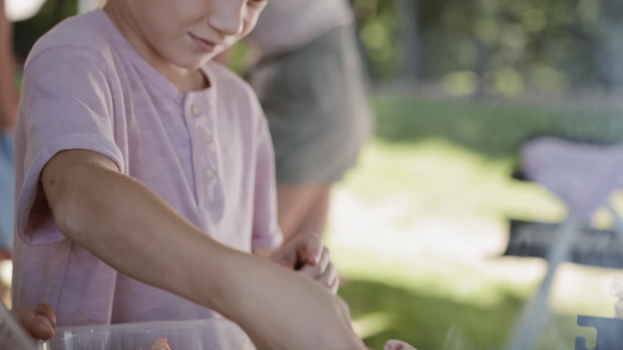 video de seguimiento de un niño ayudando con la parrilla de barbacoa