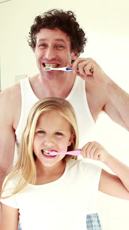 familia feliz lavándose los dientes juntos