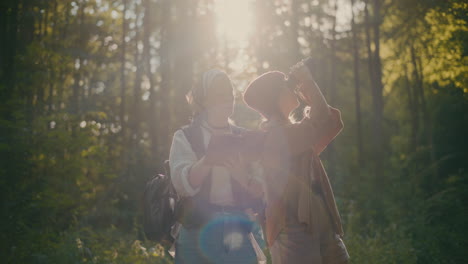 young female tourists exploring woods during vacation