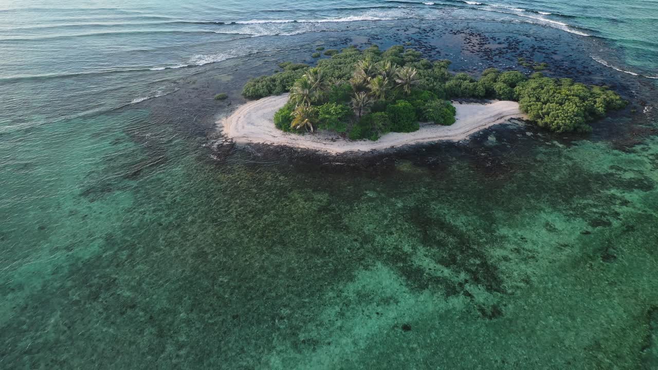 Isola tropicale isolata e disabitata con vegetazione lussureggiante e spiaggia di sabbia bianca