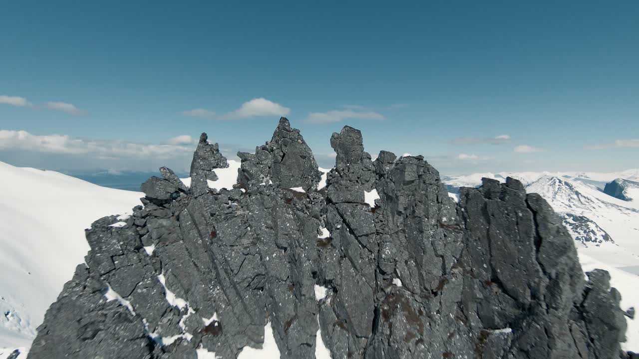 fpv 무인 항공기에서 겨울 동안 바위 산 정상을 날아서 닫습니다.