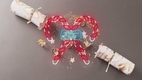 Animation-of-candy-canes-over-christmas-decorations-and-cracker