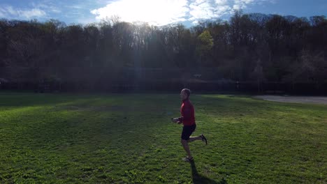 Aerial-of-a-man-running-near-a-forest-as-the-start-of-a-workout