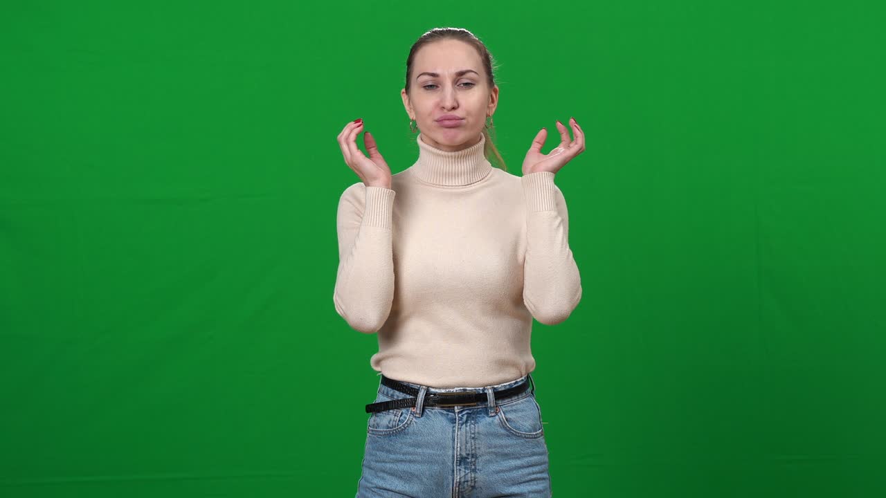 Confident professional actress making articulation warm-up at chromakey background. Portrait of beautiful slim Caucasian woman warming up facial muscles at rehearsal on green screen