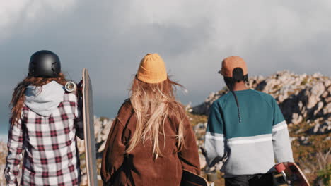 Multiethnische-Skaterfreunde-Halten-Longboards-In-Der-Hand-Und-Hängen-Gemeinsam-Rum-Und-Genießen-Die-Sommerferien-Beim-Longboarden,-Spazierengehen-Auf-Der-Landstraße-Und-Gespräch-Von-Hinten