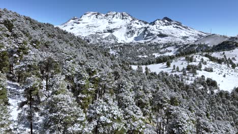 the breathtaking sight of iztaccihuatl volcano in mexico, fully covered in snow. this aerial footage highlights the majestic volcano's transformation after a heavy storm