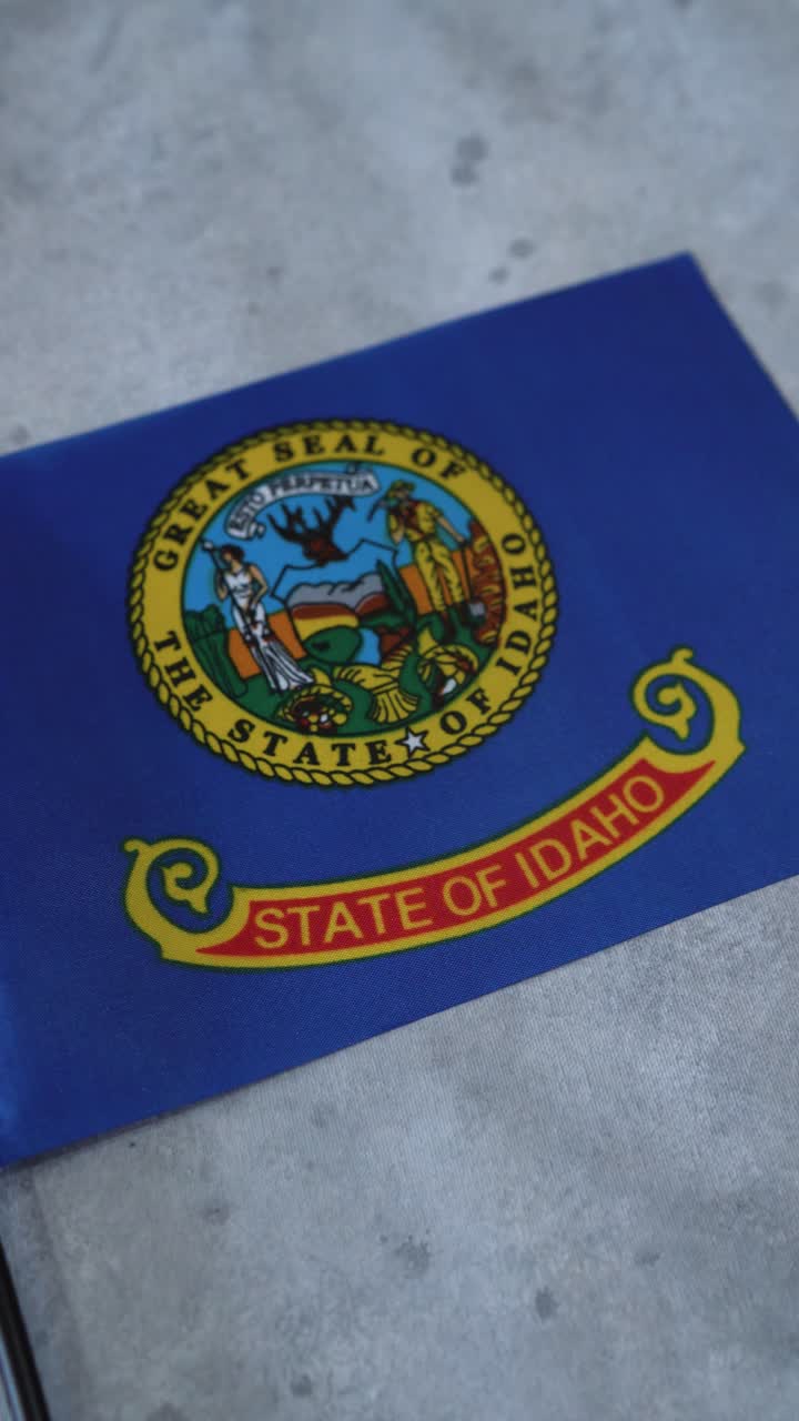 Vertikální záběr státní vlajky Idaho. Kamera obíhá a oddaluje.