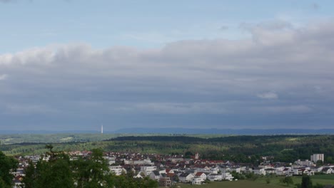 timelapse of clouds above rural town in stuttgart germany at noon, baden wurttemberg, balvaria europe