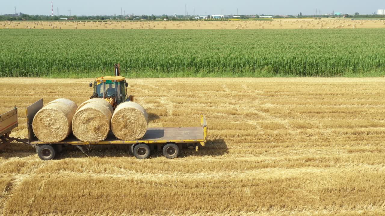 Above view of agricultural field, collecting round bales of straw