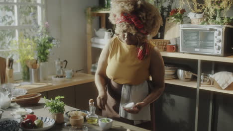 african american woman cooking and preparing food in a bright kitchen