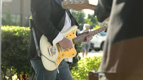 man lead guitarist playing electrical guitar at daytime outdoor concert