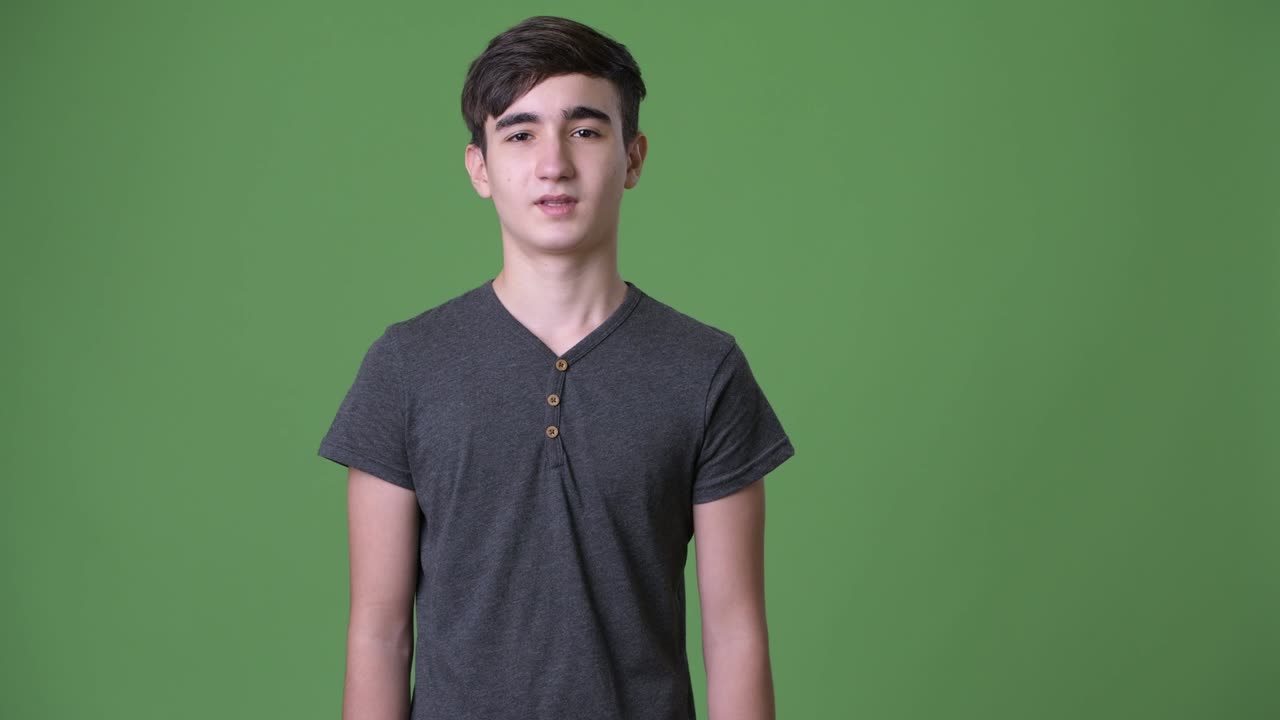 joven y guapo adolescente iraní contra un fondo verde