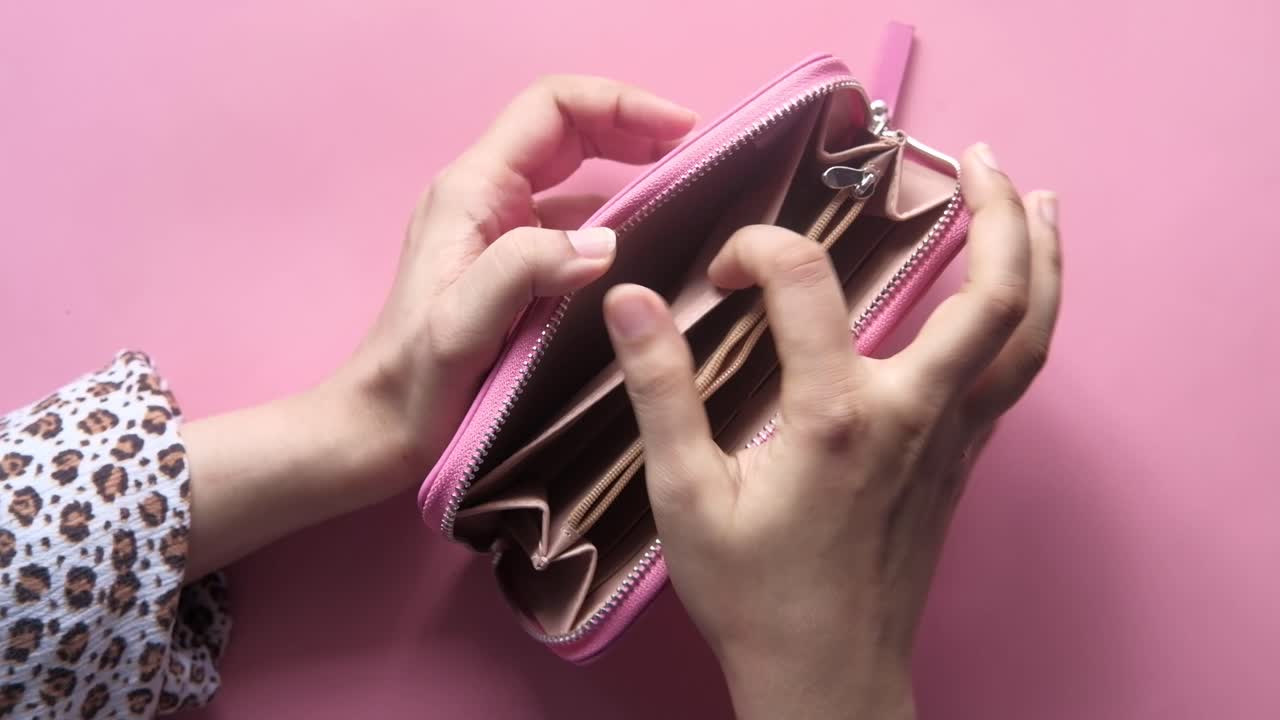 Portafoglio rosa vuoto tra le mani