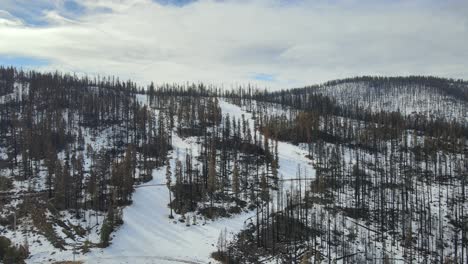 Die-Luftbildkamera-Schwenkt-Nach-Oben,-Um-In-Einer-Einzigartigen-Drohnenperspektive-Ein-Skigebiet-Zu-Zeigen,-Das-Von-Einem-Waldbrand-Abgebrannt-Ist