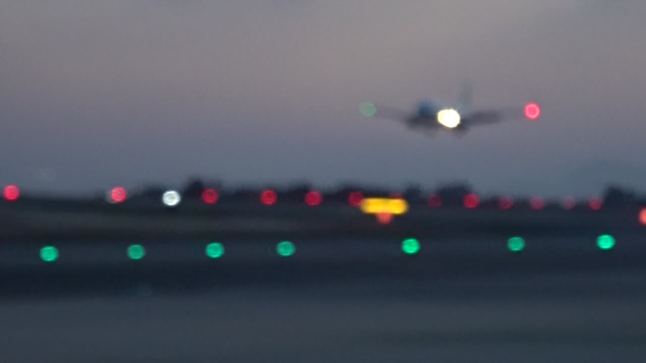 Aircraft landing on the runway full lights on. Shooted unfocused and blurry. Sunset light. May 2018. Alicante airport.
