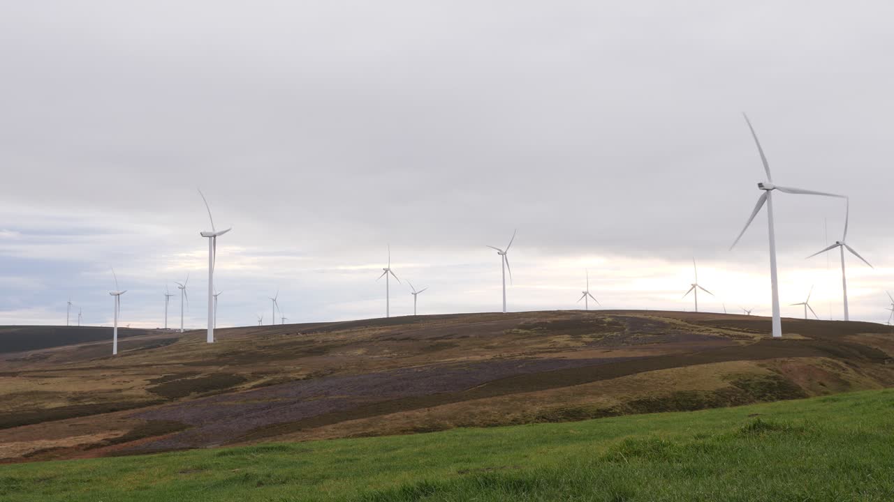 재생 가능한 전기를 생성하는 흐린 하늘 앞에서 회전하는 풍력 터빈