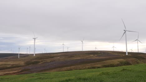 wind turbines rotating in front of overcast sky generating renewable electricity