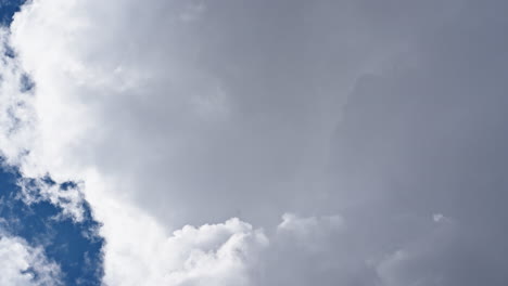 Large white cloud moving slowly across deep blue sky in a timelapse shot