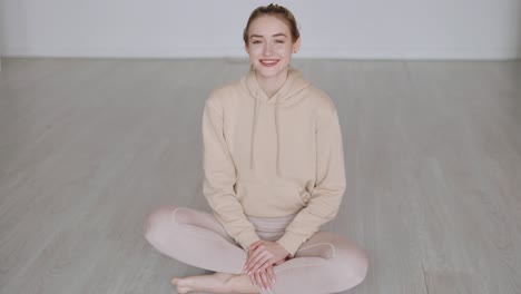 woman sitting comfortably in a hoodie and leggings