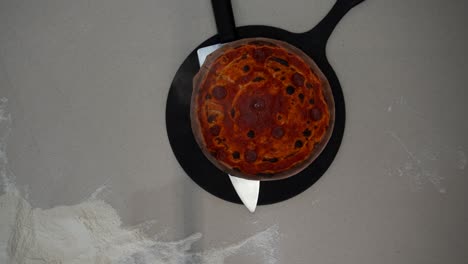Overhead view of putting sizzling hot pizza on a metal pan. Top down view of serving hot pizza with ketchup