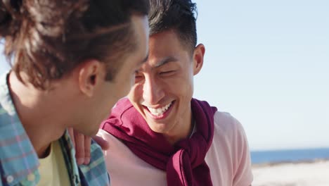 Happy-diverse-gay-male-couple-talking-at-promenade-by-the-sea,-slow-motion