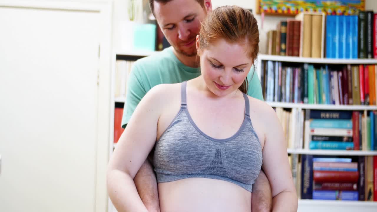 hombre afectuoso tocando el vientre de la mujer