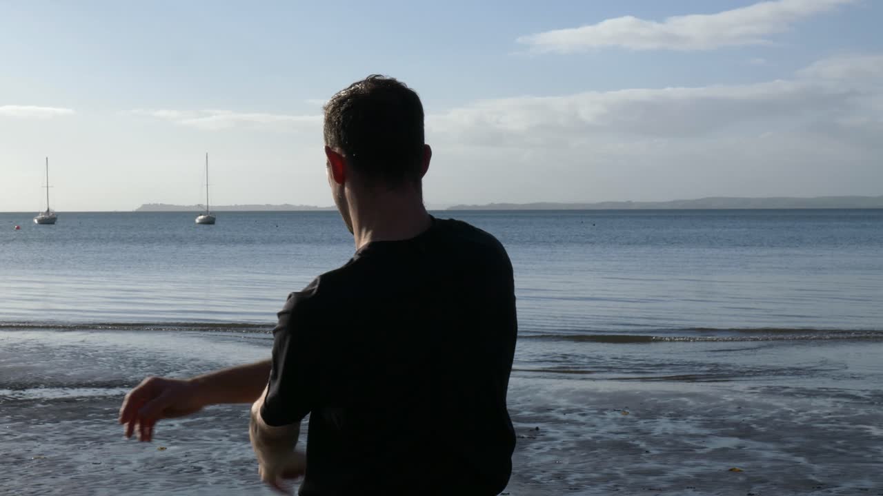 뉴질랜드 오클랜드의 해변에서 스트레칭을 하는 젊은 건강한 남자