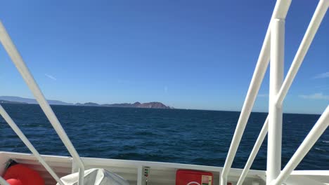 on board the boat sailing towards the cíes islands in the rías baixas seen from the front bow with the blue sea and clear sky on a sunny day, frontal blocked shot, pontevedra, galicia, spain