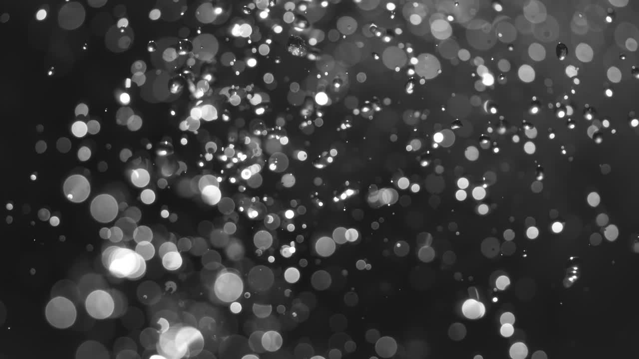 Floating abstract particle bokeh on dark background. Shot on super slow motion camera 1000 fps