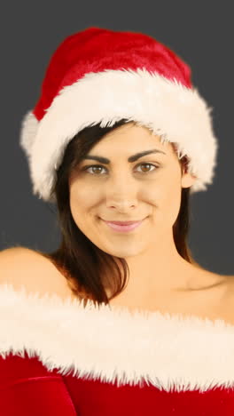 una mujer bonita sonriente posando en un traje sexy de papá noel.