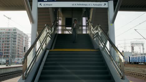 woman walking up stairs at train station