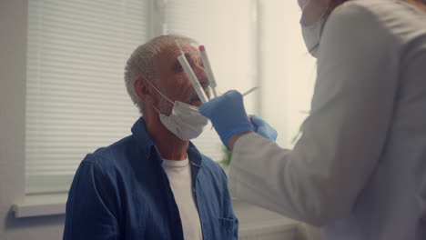 Krankenschwester,-Die-Einen-Nasenabstrich-Covid-Test-Bei-Einem-älteren-Mann-Durchführt,-Nahaufnahme.-Patient-Bei-Der-Untersuchung.