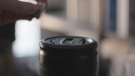 close up of hands inserting coins into a piggy bank with a counting display