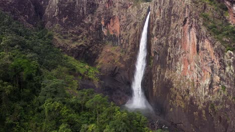 Spectacular-Wallaman-Falls-waterfall-aerial-with-water-spray-and-green-rainforest,-Queensland