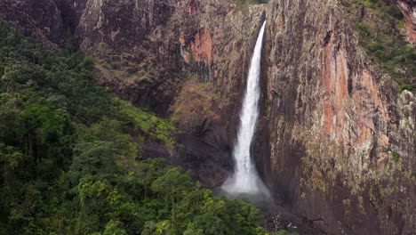 spectacular wallaman falls waterfall aerial with water spray and green rainforest, queensland