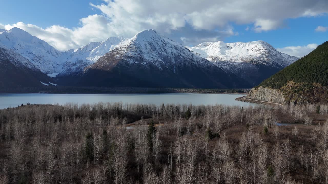 Stunning Aerial View of Snow-capped Mountains and a Calm Lake in Alaska