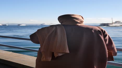 woman in hijab looks out at the sea