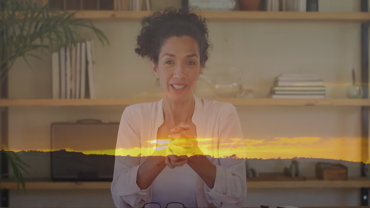 animación de paisaje de puesta de sol sobre mujer biracial hablando con la cámara.