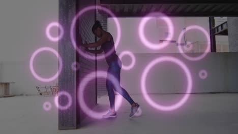Animation-of-purple-circles-flashing-over-woman-exercising-and-stretching