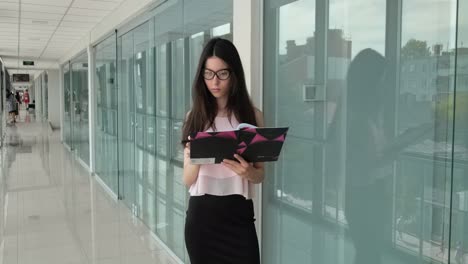focused girl with glasses reads a business project plan